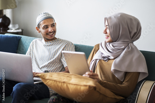 Muslim family using digital devices at home photo