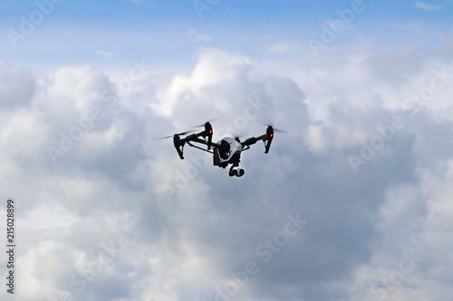 Fototapeta Naklejka Na Ścianę i Meble -  Yaslo, Poland - july 1 2018: The flight of a drone DJI X pair with video camera among the rainy clouds. Difficult weather conditions for aircraft. Use of new technologies and competition of robotics.