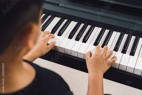 An asian boys  playing the piano.