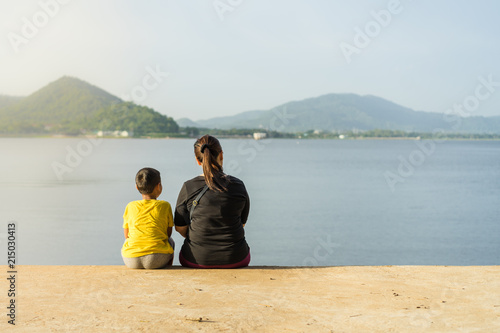Mothers and children sit at the Bang Phra reservoir in the sunset