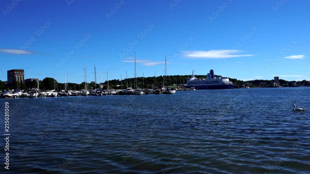 Norwegian docks and harbour with swan swimming through. Sunny weather north sea. Norwegian docks and harbour with swan swimming through. Sunny weather north sea.