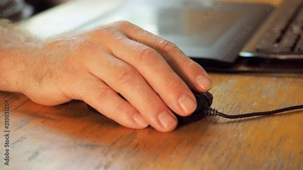 Man's hand laying on black computer mouse and scrolling mouse wheel by ...