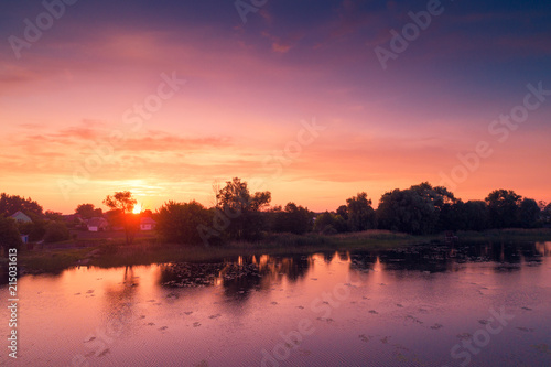 Magical purple sunrise over lake. Misty morning, rural landscape, wilderness