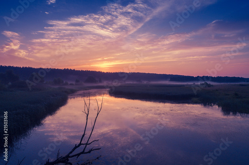 Fototapeta Naklejka Na Ścianę i Meble -  Magical purple sunrise over the lake. Misty morning, rural landscape, wilderness