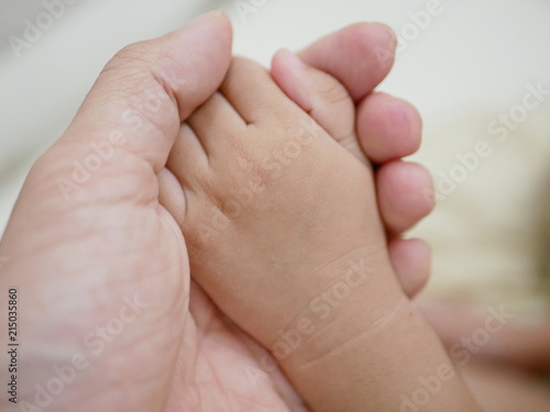 Little baby hand in her father's hand representing father's love, care, and protection