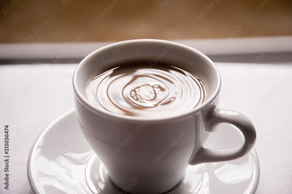 black coffee with milk in a white mug with a saucer black coffee with milk in a white mug with a saucer