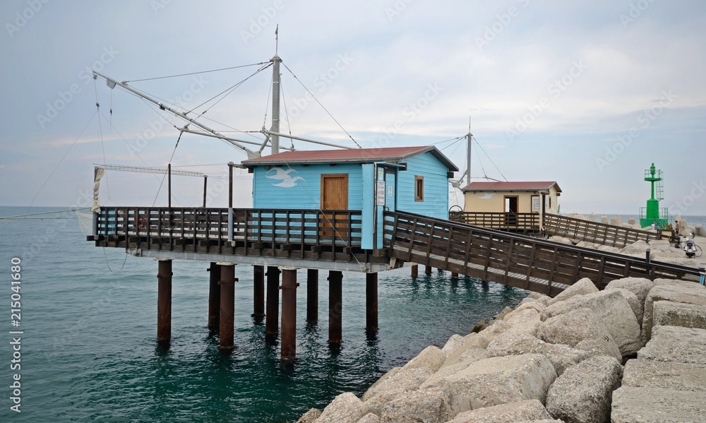 Marche, Italy, fishing huts along the port of Fano harbor in a cloudy summer day
