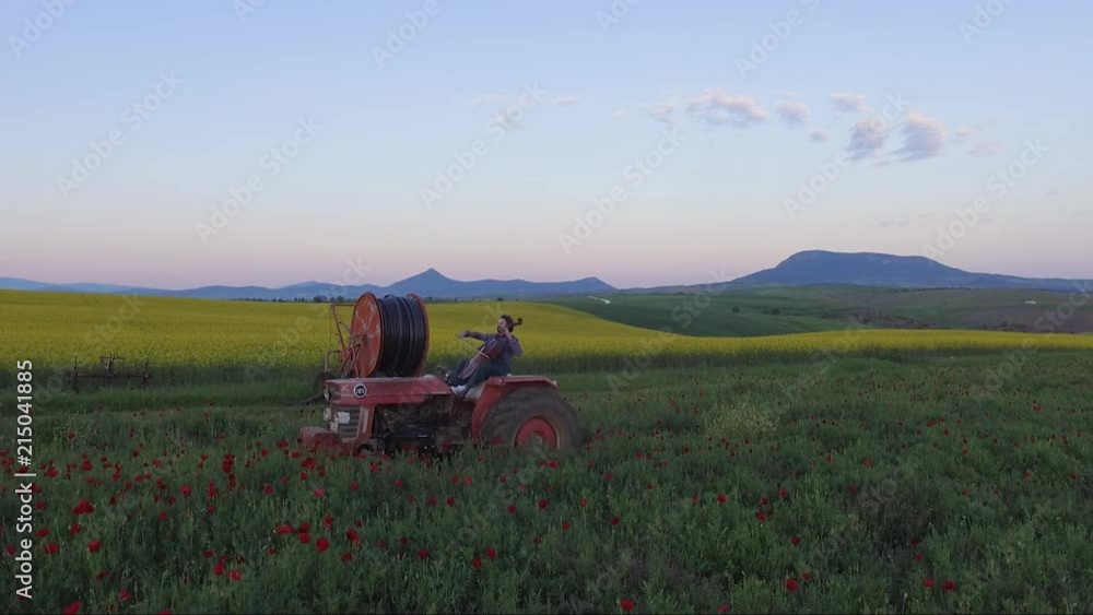 A musician is playing violoncello while driving a tractor in the fields of northern Greece. A musician is playing violoncello while driving a tractor in the fields of northern Greece.