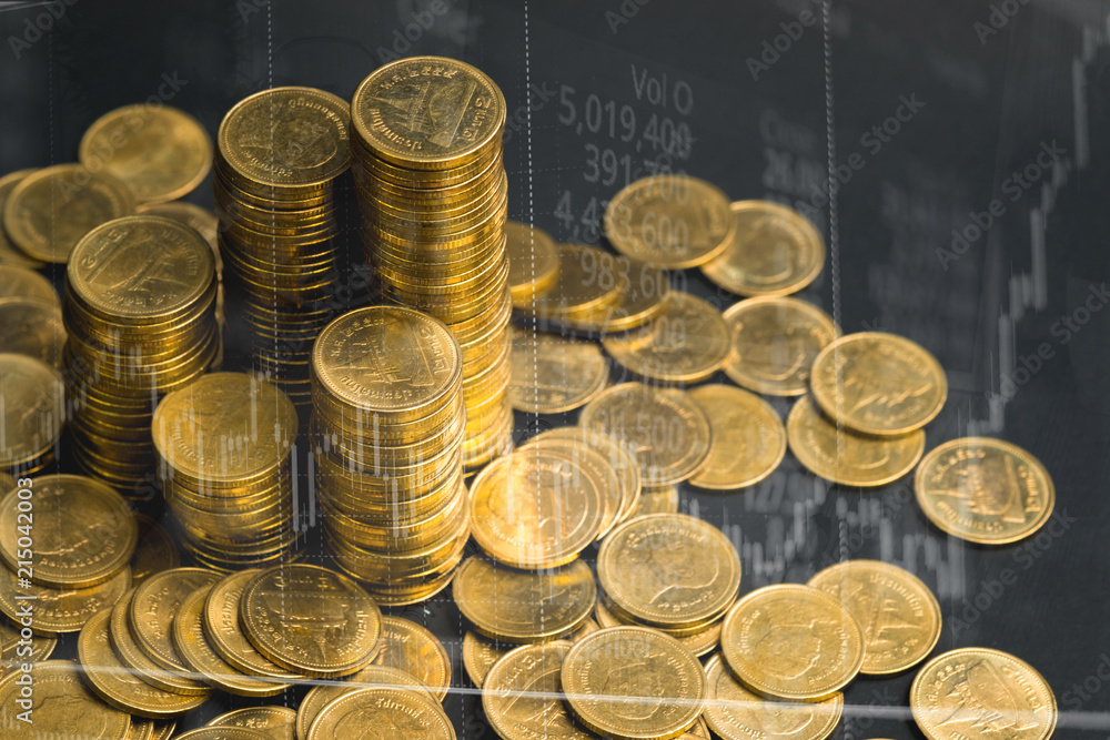 Double exposure of coin stack with stock market screen chart board and candle stick for financial business and investor analysis concept idea.