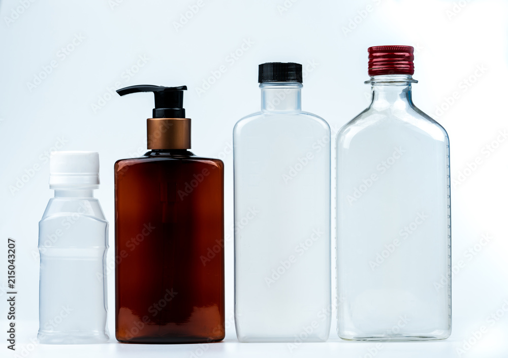 Empty plastic and glass bottle with cap and pump with black label isolated on white background. Pharmaceutical products bottle packaging.