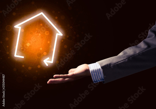 Conceptual image with hand pointing at house or main page icon o