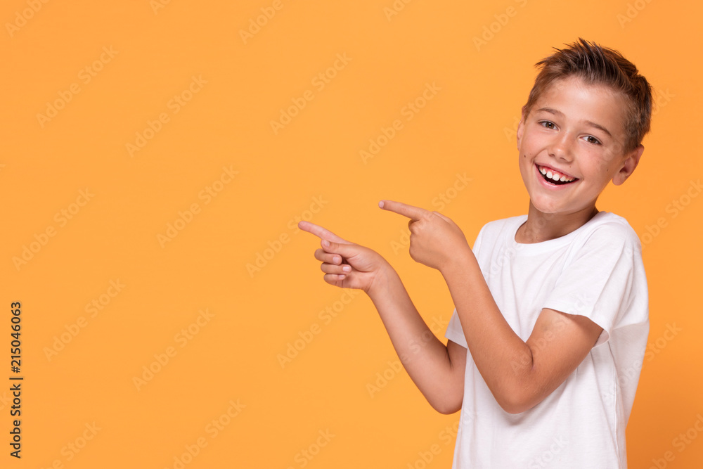 Young emotional little boy on orange studio background. Young emotional little boy on orange studio background.