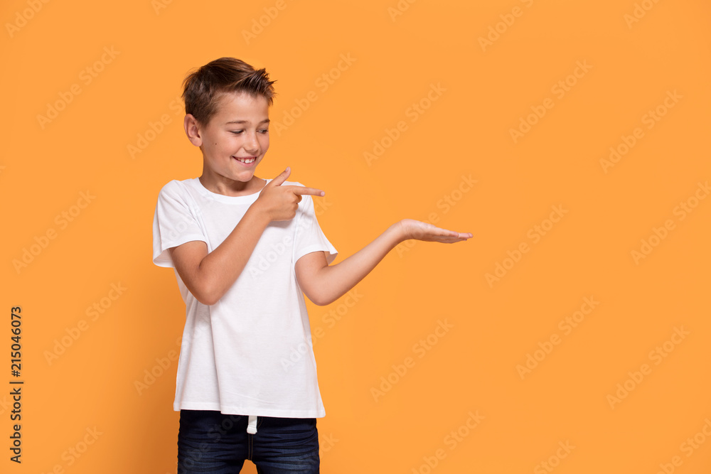 Young emotional little boy on orange studio background. Young emotional little boy on orange studio background.