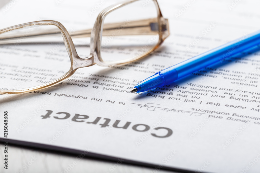Close up shot of Eyeglasses on contract document papers business concept Close up shot of Eyeglasses on contract document papers business concept