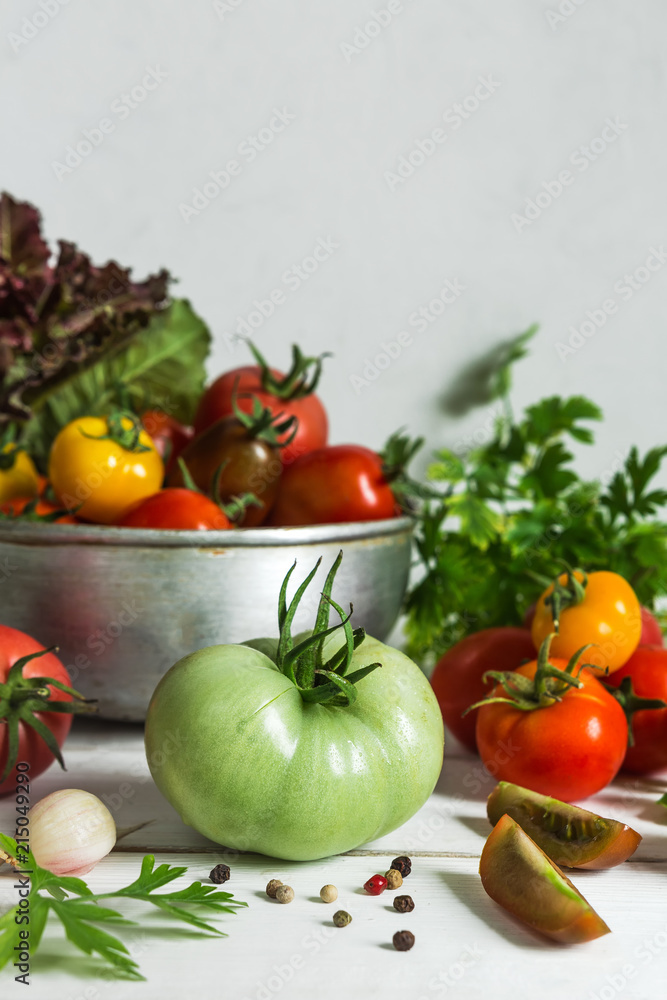 Fresh tomatoes and parsley, dill, garlic on a light background in a rustic kitchen and wooden utensils still life with a copy space Fresh tomatoes and parsley, dill, garlic on a light background in a rustic kitchen and wooden utensils still life with a copy space