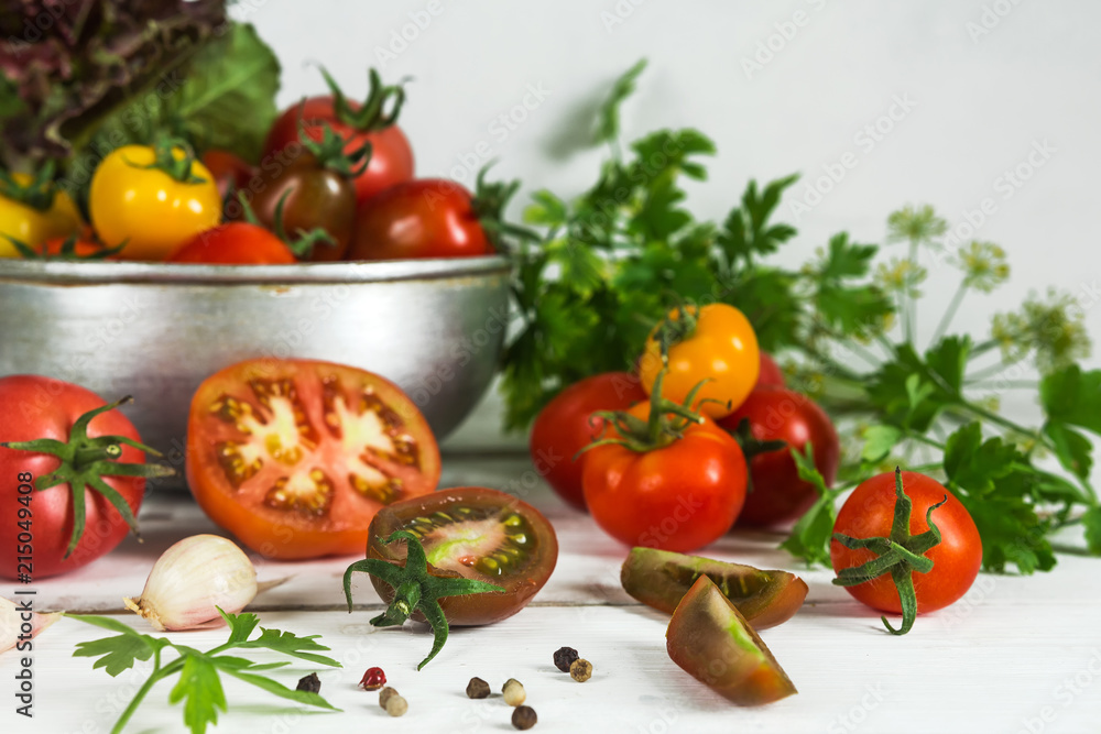 Fresh tomatoes and parsley, dill, garlic on a light background in a rustic kitchen and wooden utensils still life with a copy space Fresh tomatoes and parsley, dill, garlic on a light background in a rustic kitchen and wooden utensils still life with a copy space