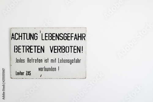 East - West German border warning sign on a white wall with copy space. Found near Wernigerode in 1990 following the reunification of Germany at the end of the Cold War.