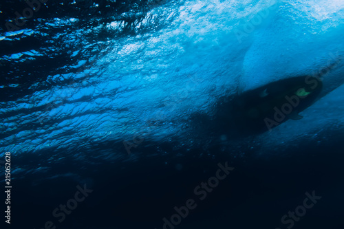 Underwater barrel wave in tropical ocean and surfboard