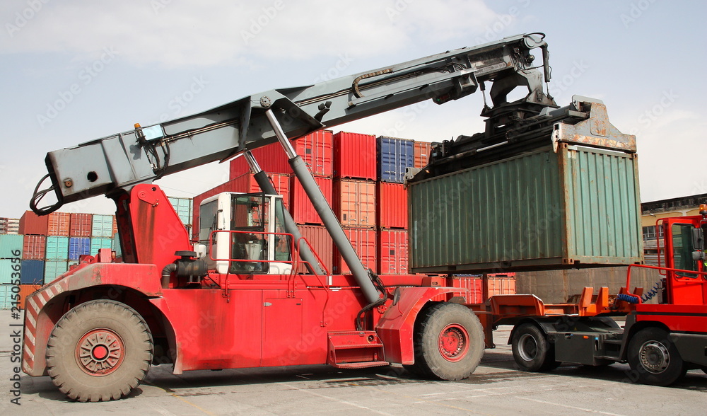 Reach stacker vehicle moving a container into a container terminal area