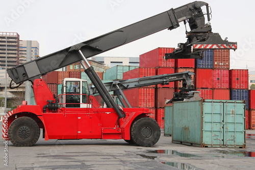 Reach stacker vehicle moving a container into a container terminal area