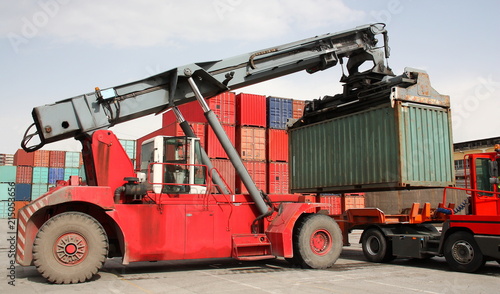 Reach stacker vehicle moving a container into a container terminal area