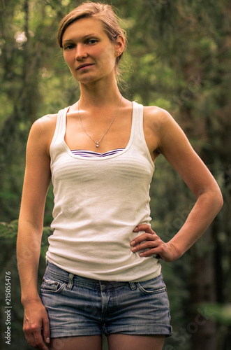 Young woman in a white tank top in the forest © Michael Kachalov