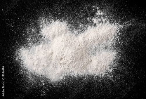 Pile of wheat flour isolated on black background, powder texture, top view with clipping path