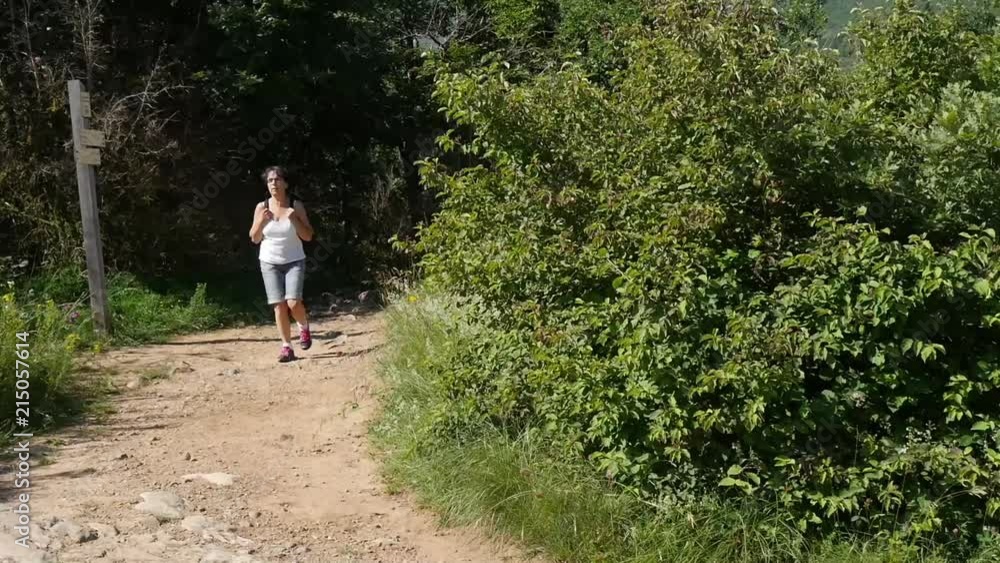 female hiker walking on a mountain trail female hiker walking on a mountain trail