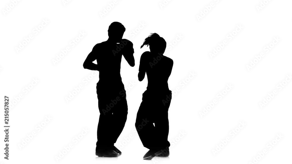Kickboxer girl kicks on the head of an opponent. Silhouette. White background. Slow motion Kickboxer girl kicks on the head of an opponent. Silhouette. White background. Slow motion