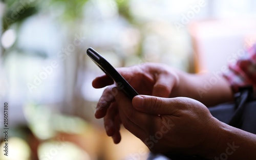 People hand using smartphone closeup interior blur background. Concept of Technology