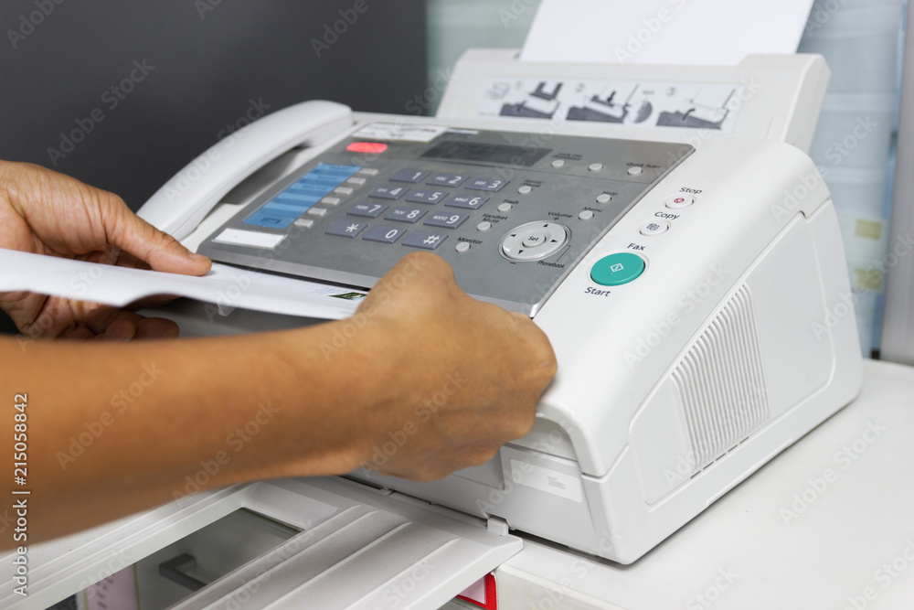 hand man are using a fax machine in the office. Business concept hand man are using a fax machine in the office. Business concept
