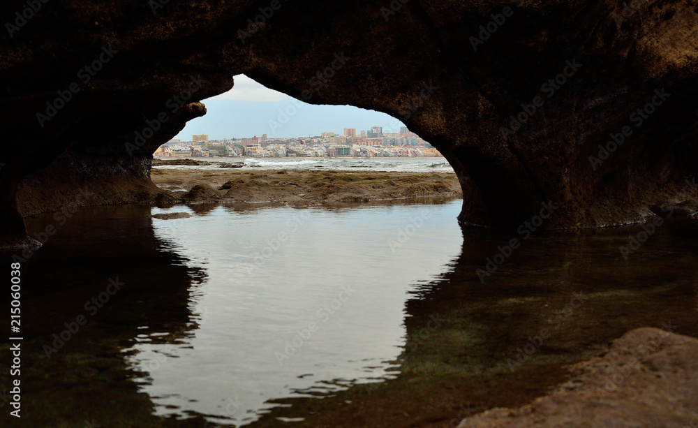 Hole on the rock and city view during low tide, Las Palmas de Gran Canaria, Canary islands