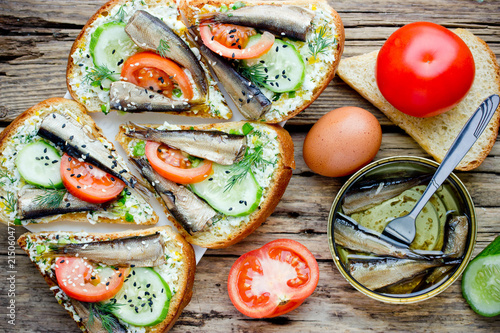 Smoked sprat fried sandwiches with boiled egg, tomato, cucumber and sesame