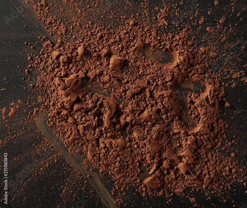 Cocoa powder pile isolated on black background, top view