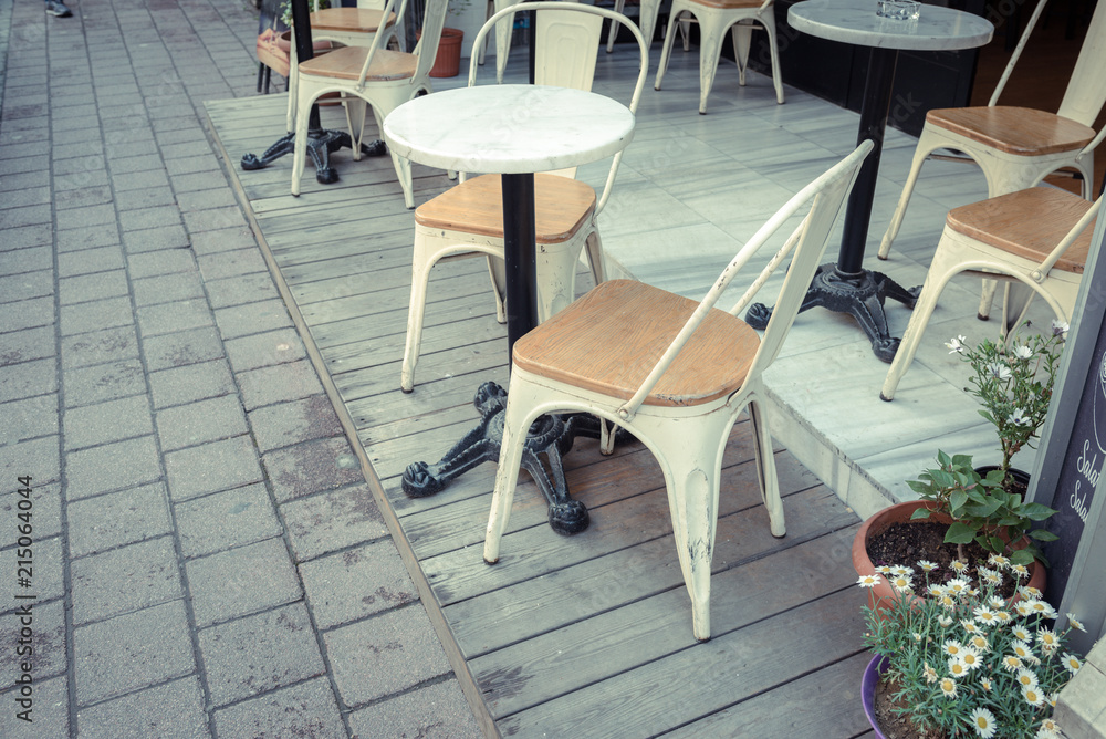 Retro, vintage view of Pastel cafe chairs,tables chair and wild daisy pot on corner in Balat, old town of Istanbul, Turkey. Outdoor cafe. Photo in vintage image style.ISTANBUL, TURKEY