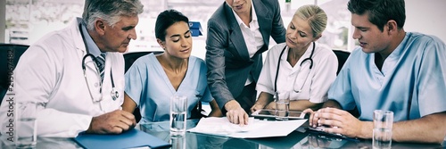 Quadro em tela Team of doctors and businesswoman having a meeting