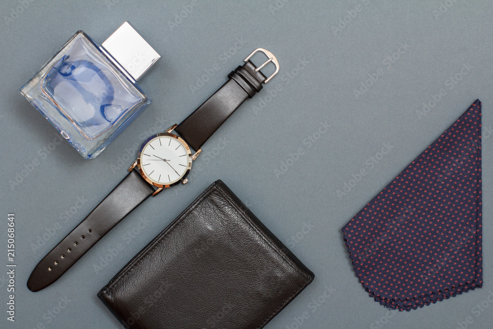 Leather purse, watch with a black leather strap, cologne for men and handkerchief on grey background Leather purse, watch with a black leather strap, cologne for men and handkerchief on grey background
