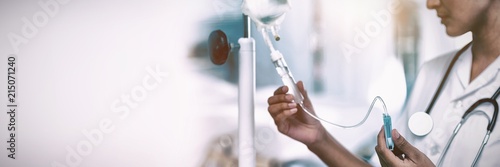 Slika na platnu Nurse connecting an intravenous drip