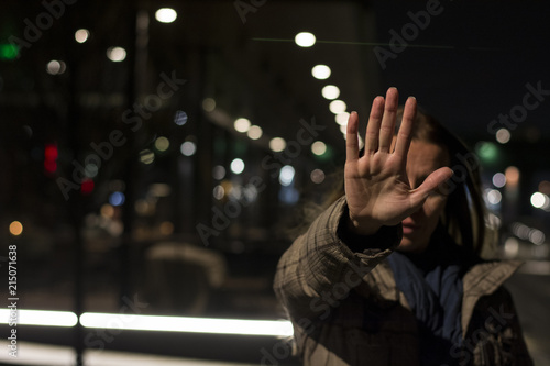 Woman showing hand stop sign while standing at night