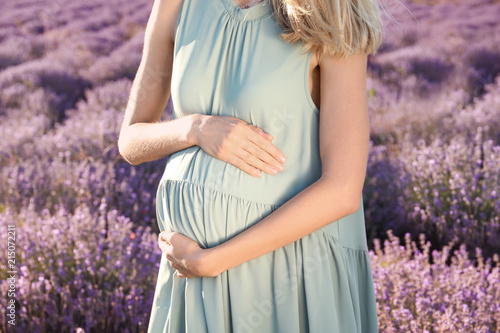 Fototapeta Naklejka Na Ścianę i Meble -  Pregnant woman in lavender field on summer day