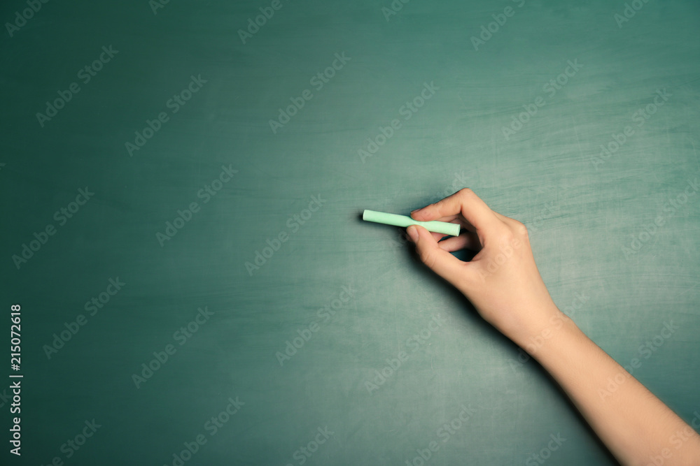 Woman writing with piece of chalk on board Woman writing with piece of chalk on board