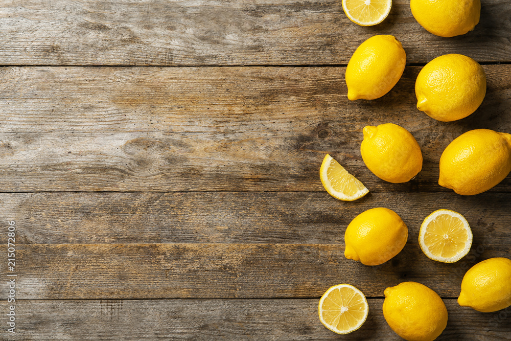 Flat lay composition with whole and sliced lemons on wooden background Flat lay composition with whole and sliced lemons on wooden background