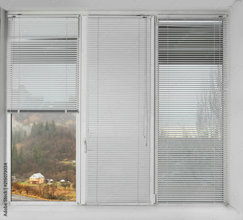 Window with open blinds and beautiful view of landscape Window with open blinds and beautiful view of landscape