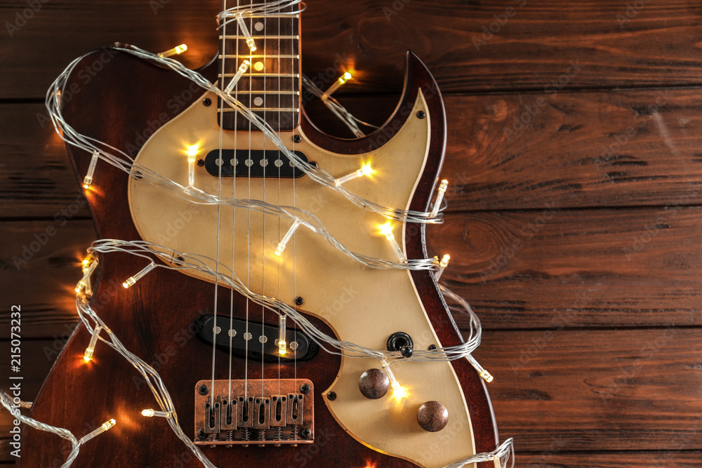 Guitar with fairy lights on wooden background, top view. Christmas music  concept Stock Photo | Adobe Stock