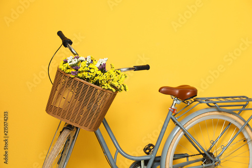 Retro bicycle with wicker basket on color background photo