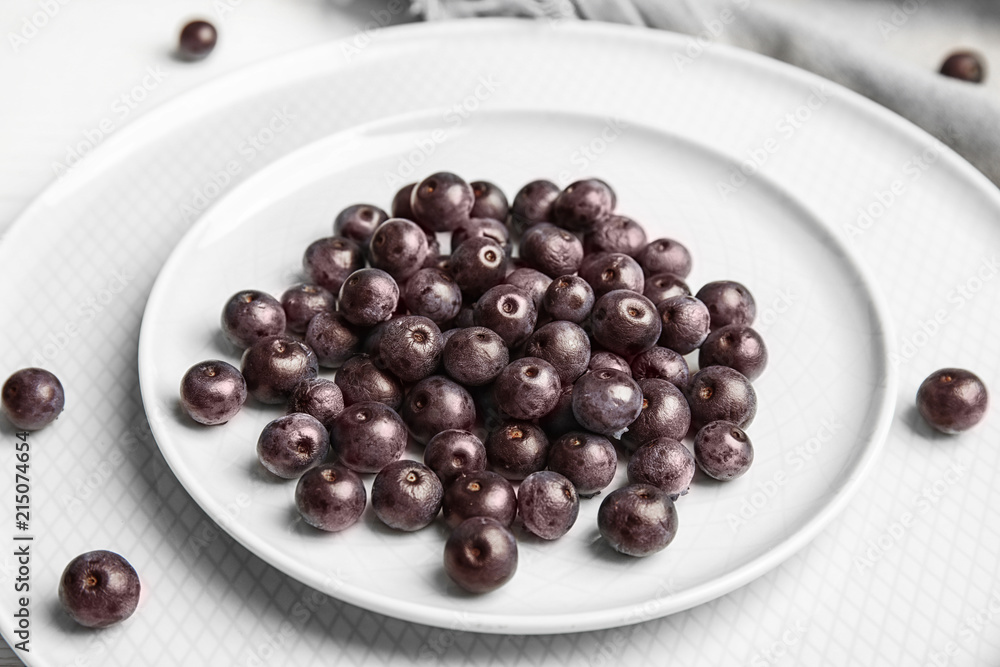 Plates with fresh acai berries on table, closeup Plates with fresh acai berries on table, closeup