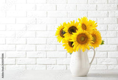 Fototapeta Naklejka Na Ścianę i Meble -  Jug with beautiful yellow sunflowers on table