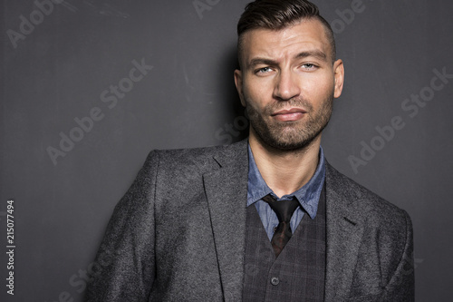 Obraz na płótnie Portrait of stylish, elegant young man in suit with an impudent and prejudiced expression. Brutal young businessman. w salonie