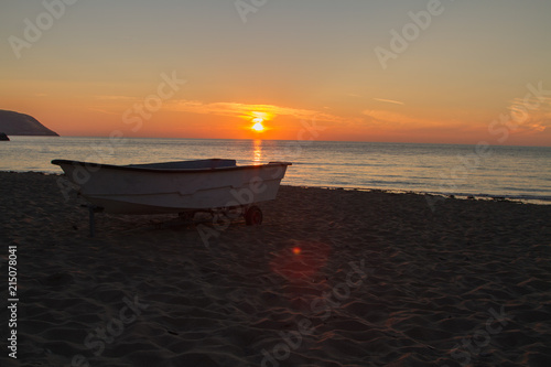 a Small fishing boat on the beach at Tresaith at sunset photo