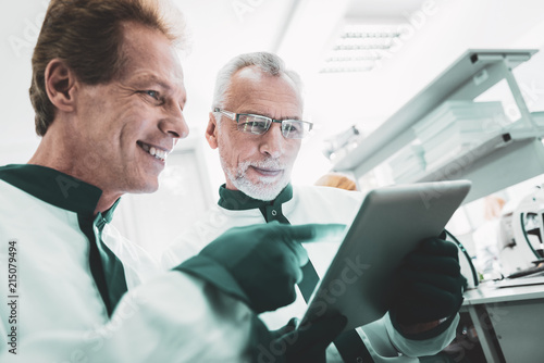 Professional equipment. Two modern promising scientists standing near professional equipment while working in laboratory